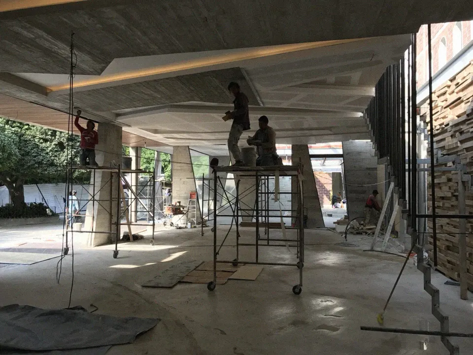 Obreros sobre andamios levantando la losa en obra